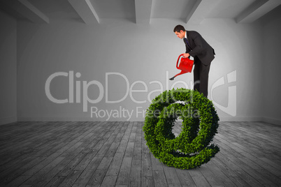 Composite image of businessman watering with red can