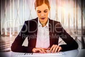 Composite image of businesswoman typing on keyboard at desk