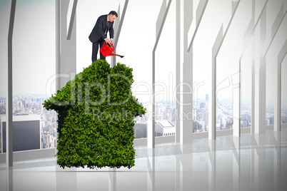 Composite image of mature businessman using watering can