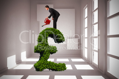 Composite image of businessman watering with red can