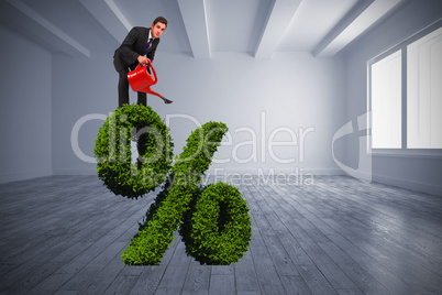 Composite image of businessman watering with red can