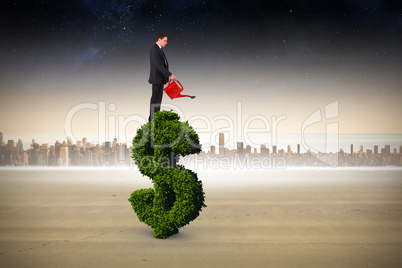 Composite image of businessman holding red watering can