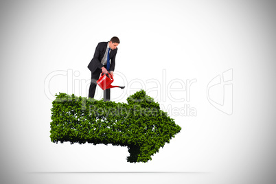 Composite image of businessman holding red watering can