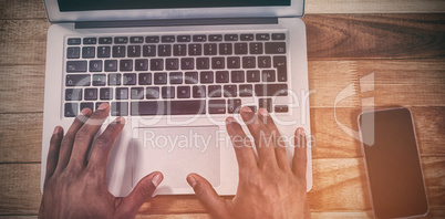 Cropped hands of businessman using laptop