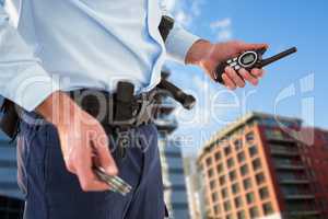 Composite image of mid section of security officer holding hand cuff and walkie talkie