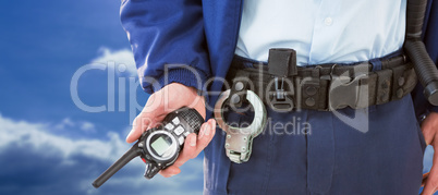 Composite image of mid section of security officer holding walkie talkie