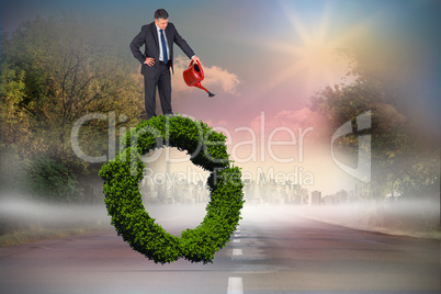 Composite image of mature businessman using watering can