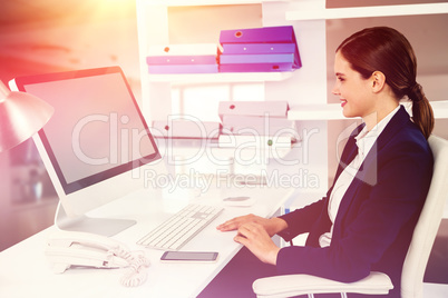 Composite image of smiling businesswoman working on computer