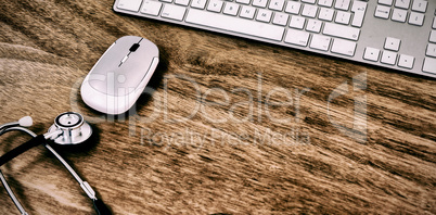 High angle view of wireless computer mouse and keyboard with stethoscope