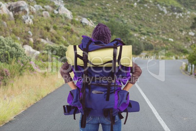 Traveler holding hicking bag on the road