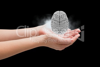 Brain on hands against black background