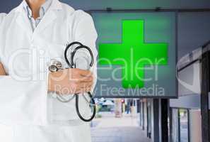 doctor model is holding stethoscope against pharmacy background