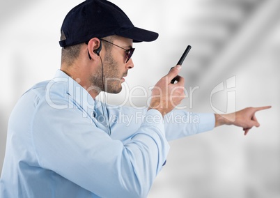 security guard with headphones and speaking with the walkie-talkie. Light blurred background