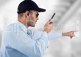 security guard with headphones and speaking with the walkie-talkie. Light blurred background