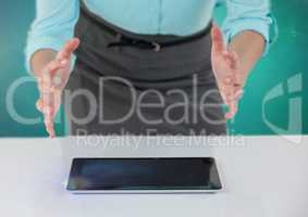Businesswoman with open hands over tablet on desk