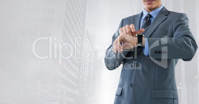 Businessman holding watch with bright city background