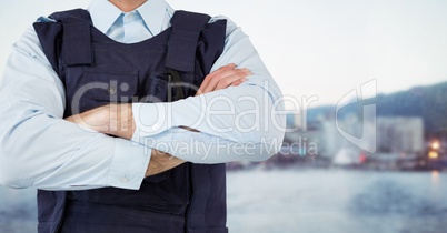 Security guard mid section arms folded against blurry skyline