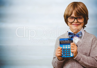 Boy smiling with calculator against blurry blue wood panel