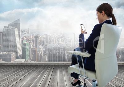 Businesswoman Back Sitting in Chair with mobile phone over city