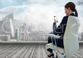 Businesswoman Back Sitting in Chair with mobile phone over city