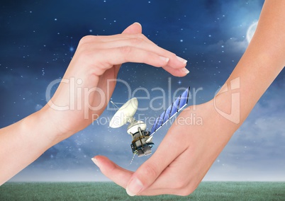 solar panel satellite between hands at night