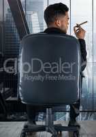 Businessman Back Sitting in Chair with  cigar and dark modern stylish windows overlooking city