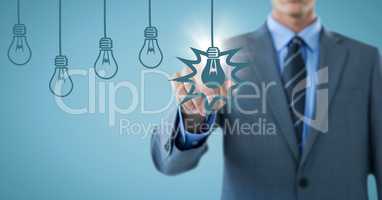 Business man mid section touching blue bulb graphics with flare against blue background