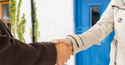 handshake in front of the door of the house