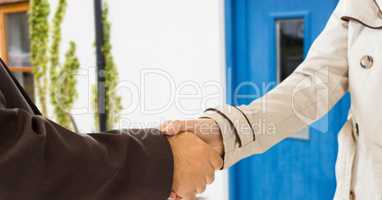 handshake in front of the door of the house