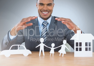 Man with cut outs of home insurance car and family