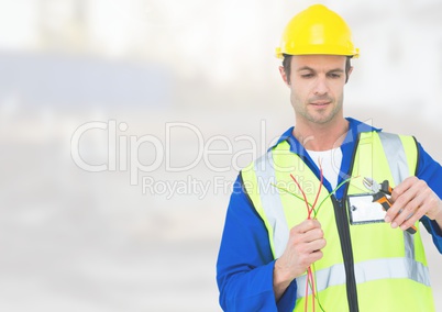 Electrician with wires cables on building site