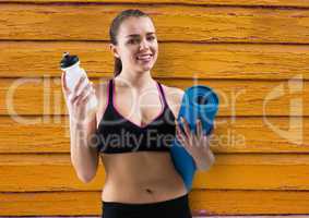 fitness woman, water and yoga mat with yellow wood background