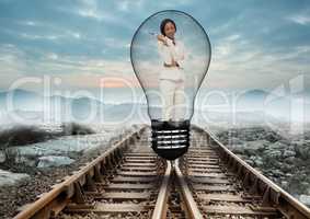 Beautiful woman standing in bulb on railway track against sky