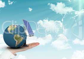 Digital composite image of hand holding planet earth and solar panel against sky