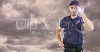 Portrait of security guard holding flashlight against cloudy sky