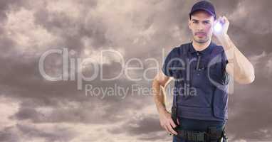Portrait of security guard holding flashlight against cloudy sky
