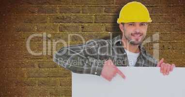Male architect holding billboard while standing against brick wall