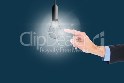 Businessman touching a light bulb with blue background
