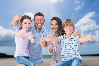 Family with their thumbs up on the beach