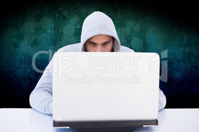 hacker using his laptop against dark background
