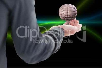 Business man holding a brain on his hand against black background