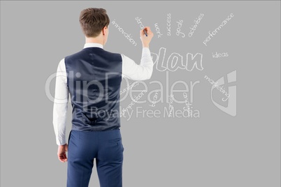 Businessman is drawing on screen against grey background