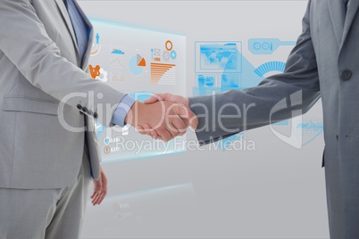 Handshake between two businessman against graphics background