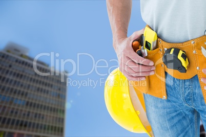 architect is touching his tool belt against building background