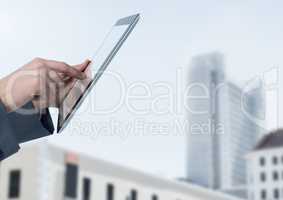 Businessman holding tablet in front of buildings