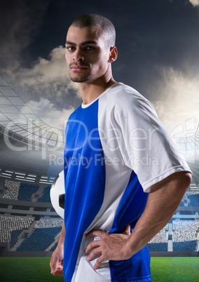 soccer player with his hands on the waist and with ball on his arm.