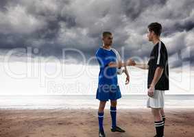 Soccer players in the beach giving the hands with clouds on the sky