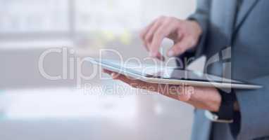 Businessman holding tablet in bright office