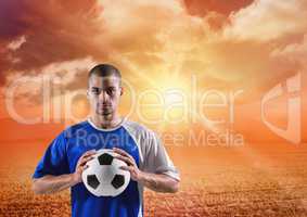 soccer player with ball on his hands in the sunset