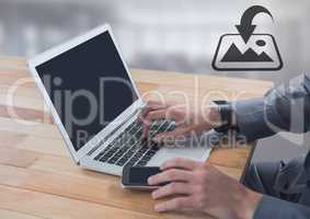 Businessman on laptop with download icon by windows